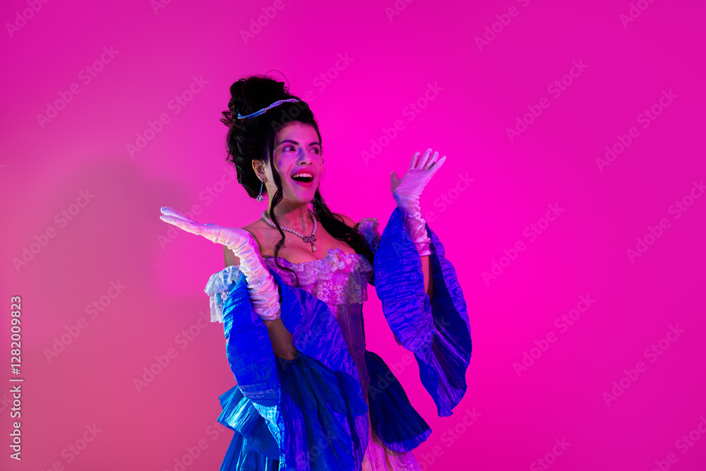 Fototapeta premium Young woman dressed in an elegant royal costume with glowing neon hues on a vibrant pink backdrop