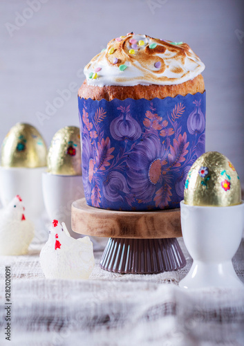 Obraz na płótnie Easter cake, chocolate eggs in gold foil and chicken-shaped candles on a light background. w salonie