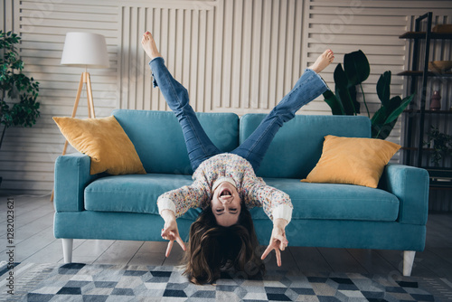 Joyful young woman in casual wear enjoying on sofa in bright cozy living room photo