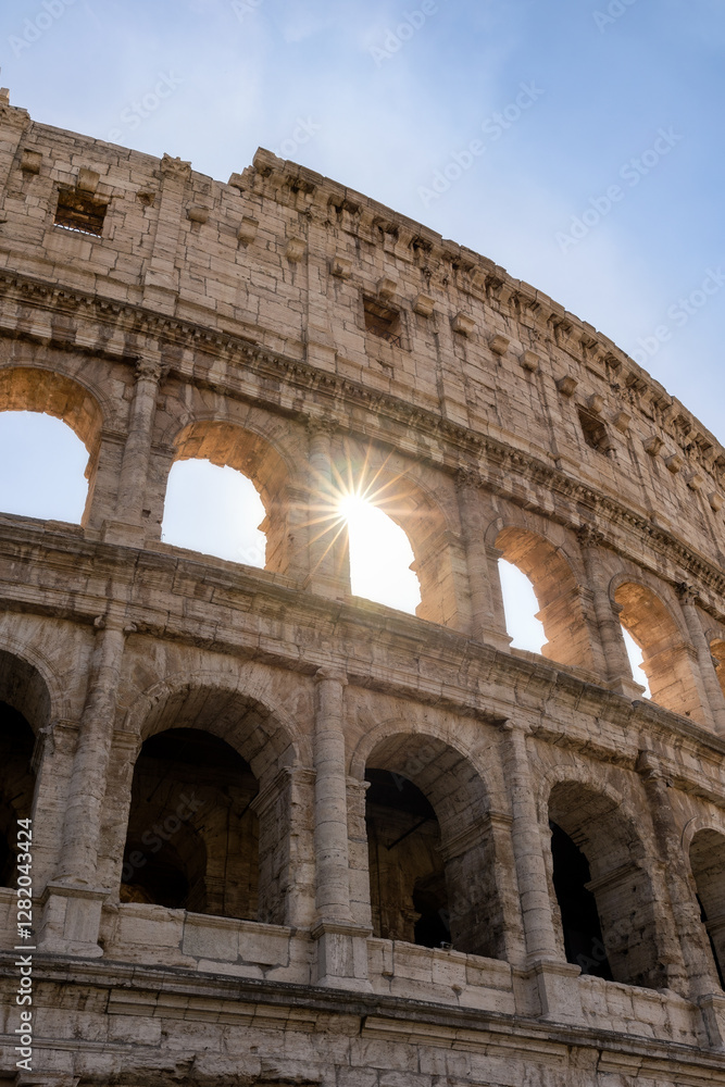 Obraz premium Roman Colosseum at sunset with sun rays coming through the structure. Rome, Italy