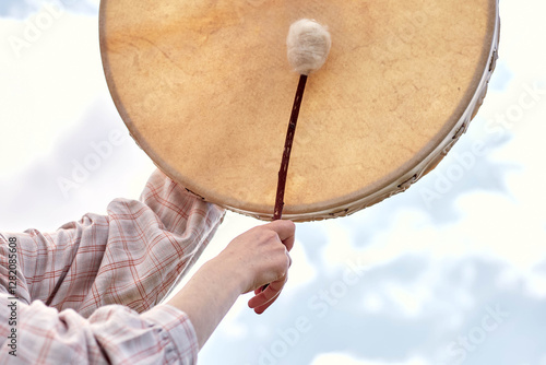 girl playing shamanic drum
