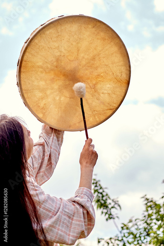 girl playing shamanic drum
