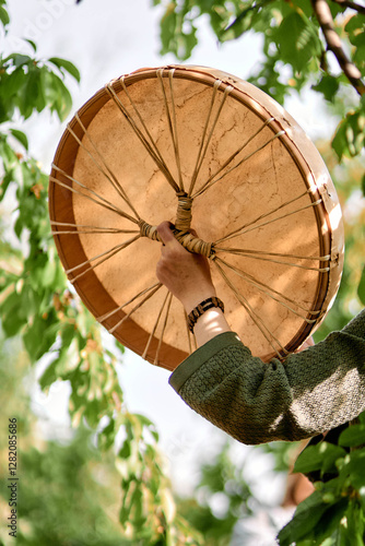 girl playing shamanic drum
