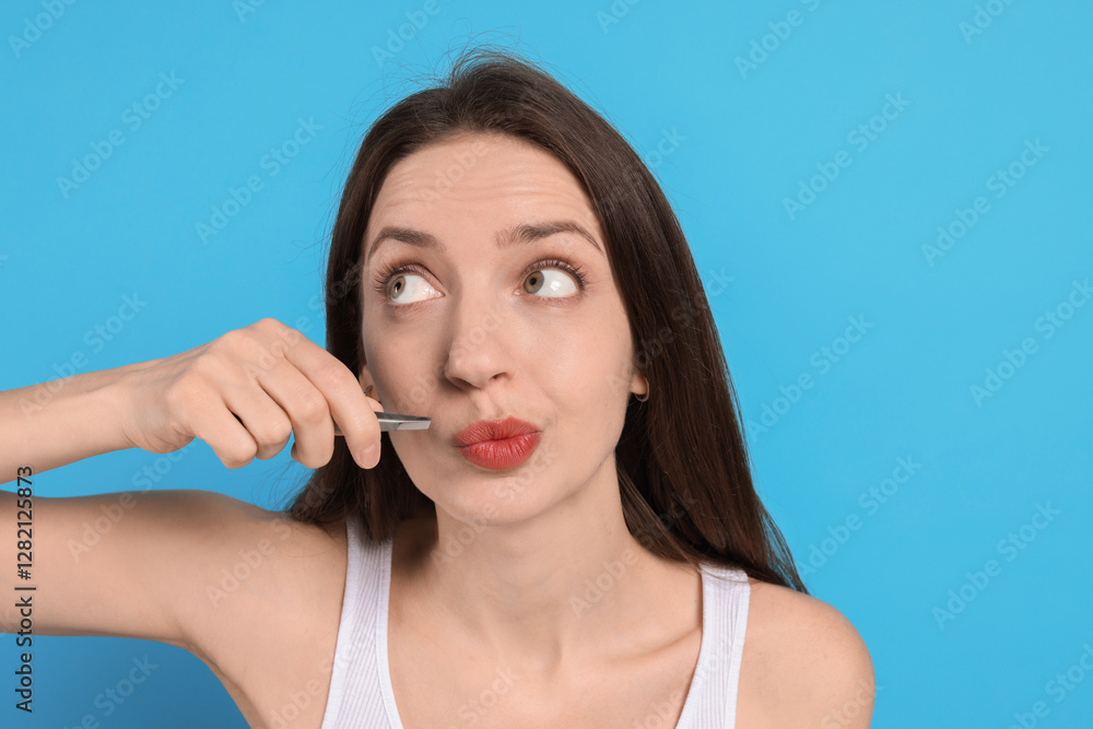 Woman plucking her mustache with tweezers on light blue background Woman plucking her mustache with tweezers on light blue background
