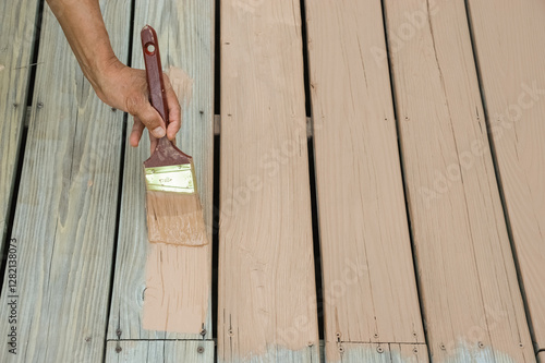 Wallpaper Mural handyman painting the wooden deck with brush Torontodigital.ca