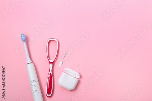 Daily dental care essentials include toothbrush, floss, and interdental cleaner on a soft pink background