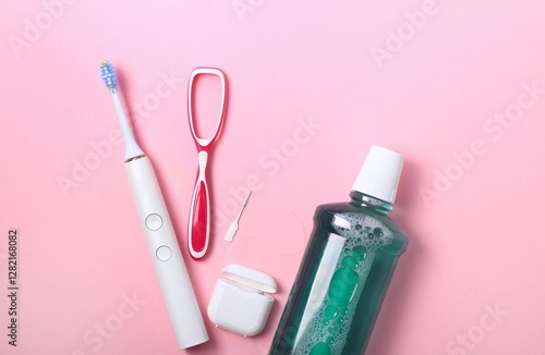 Daily dental care essentials arranged on a light pink surface with toothbrush, mouthwash, and flossing tools