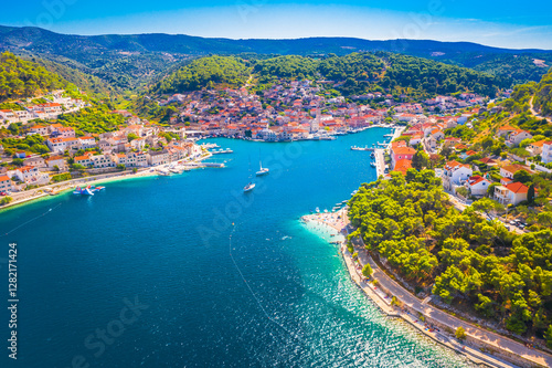 A breathtaking aerial view of Pucisca on Brac Island, Croatia, showcasing its deep bay, traditional stone houses, and stunning Adriatic coastline, capturing the charm of this picturesque town