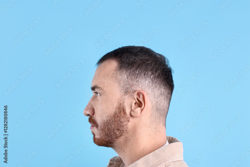 Baldness problem. Man with receding hairline on light blue background Baldness problem. Man with receding hairline on light blue background