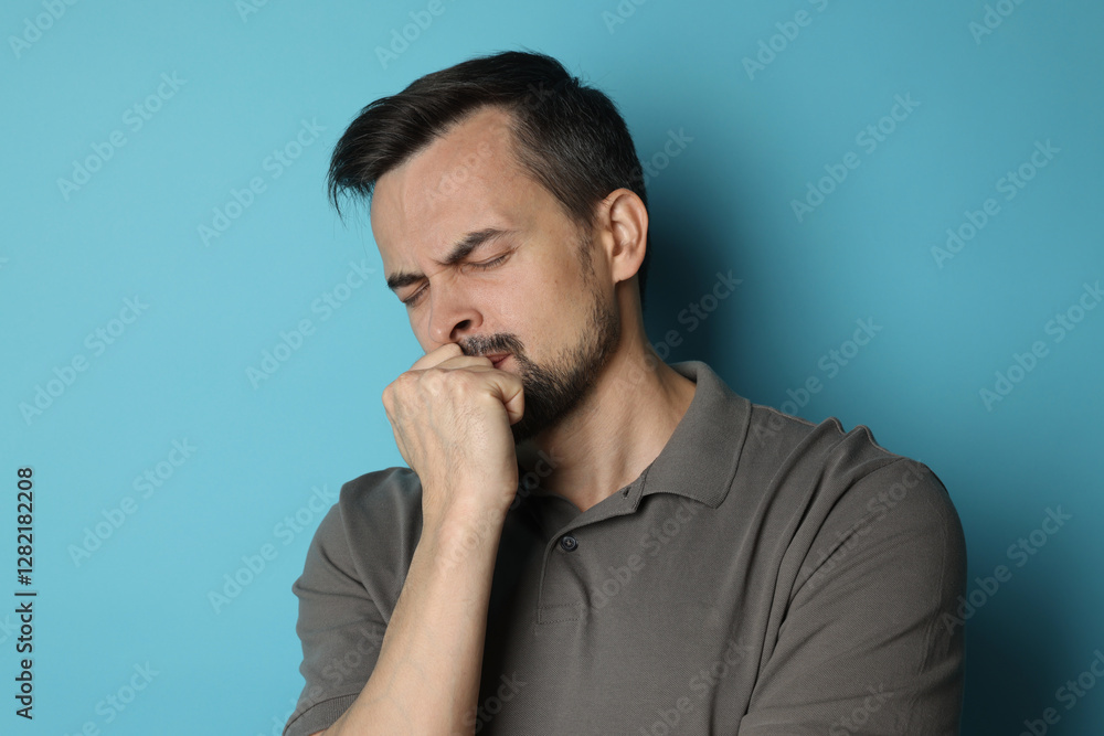 Sad man crying on light blue background Sad man crying on light blue background