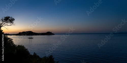 Portoferraio à la tombée de la nuit avec son phare, un voilier en rade et un peu de végétation au premier plan, Île d'Elbe, Italie
 photo