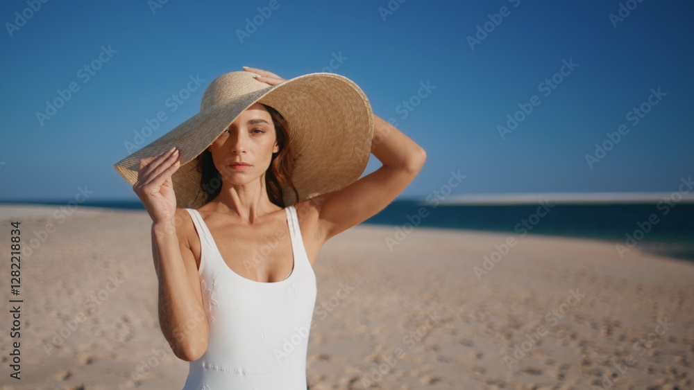Stylish model posing beach wearing straw hat closeup. Gorgeous woman on shore Stylish model posing beach wearing straw hat closeup. Gorgeous woman on shore