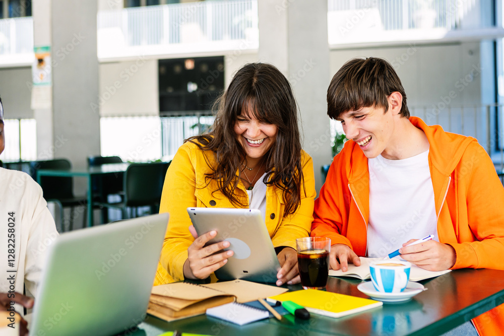 Young group of student friends doing homework or preparing exam together sitting on table at campus college. Education lifestyle concept Young group of student friends doing homework or preparing exam together sitting on table at campus college. Education lifestyle concept