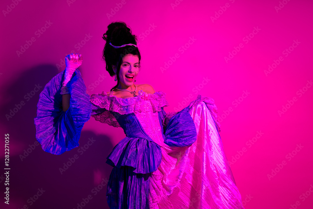 Fototapeta premium Elegant young woman in vibrant costume posing under neon purple and pink lighting in a baroque inspired artistic setting