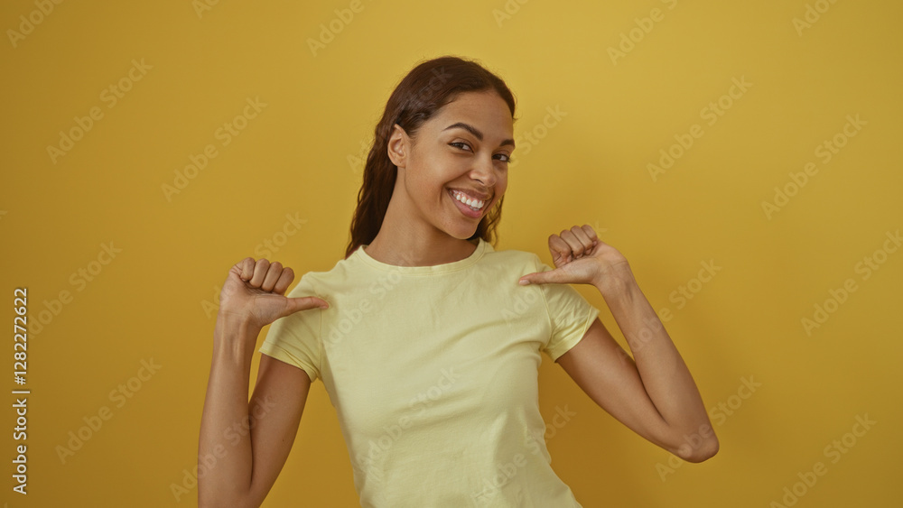 Young woman pointing at herself over an isolated yellow background smiling confidently portraying a positive attitude Young woman pointing at herself over an isolated yellow background smiling confidently portraying a positive attitude