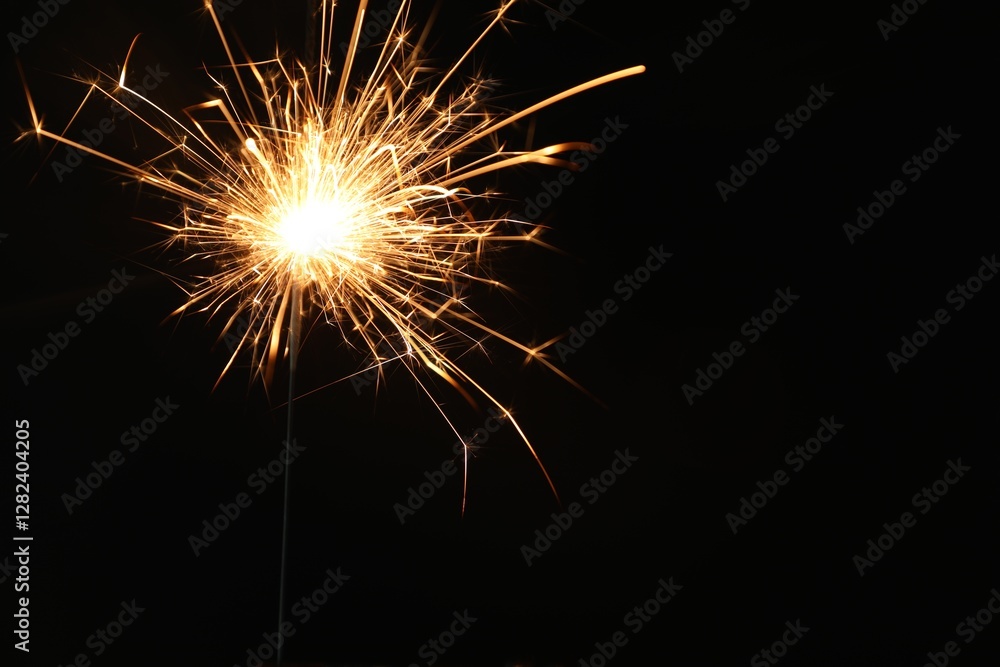 Bright burning sparkler on black background, closeup. Space for text Bright burning sparkler on black background, closeup. Space for text