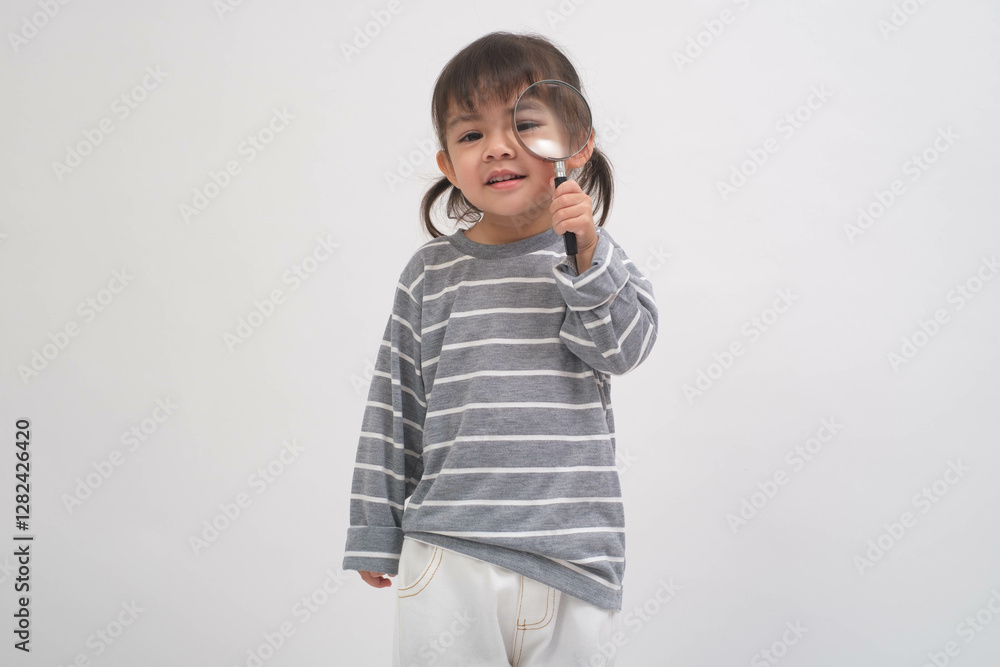 A curious child with pigtails examines the world through a magnifying glass, wearing a striped sweater. The joy of discovery in a bright setting. A curious child with pigtails examines the world through a magnifying glass, wearing a striped sweater. The joy of discovery in a bright setting.