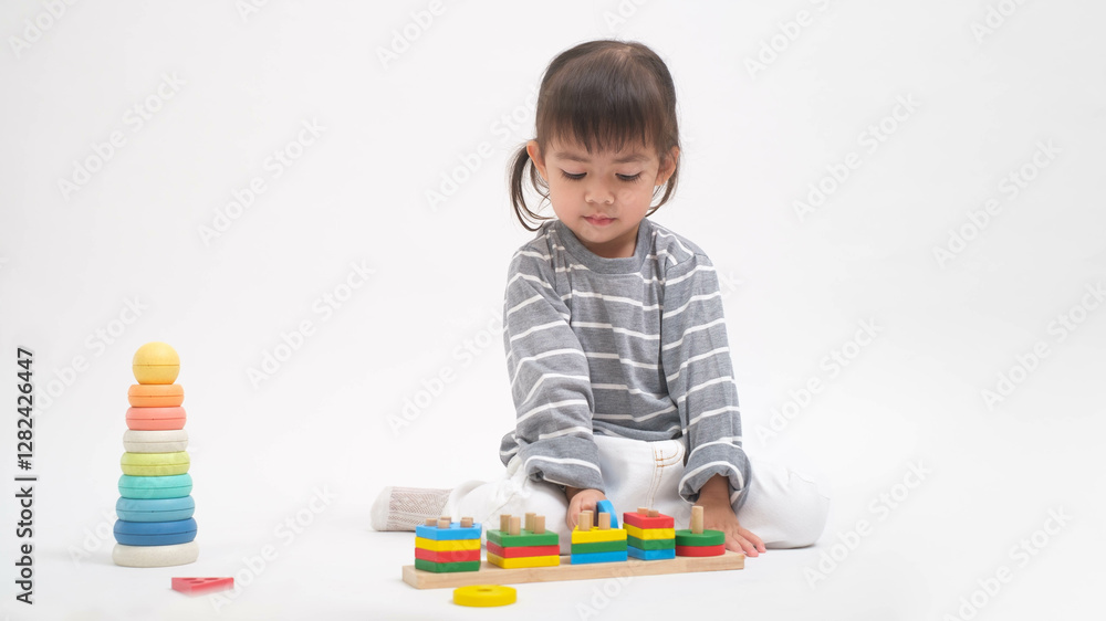 A young child plays with colorful educational toys, stacking and sorting objects on a white background, fostering creativity and learning. A young child plays with colorful educational toys, stacking and sorting objects on a white background, fostering creativity and learning.