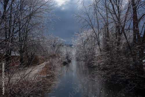 Branches of trees glistening in the sunlight after an ice storm, hang over the tow paths and the Delaware Canal Trail during a cold winter day. photo