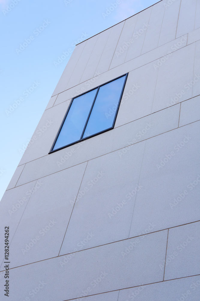 Building, glass window and architecture with blue sky in city below for industrial development or infrastructure. Low angle, structure or construction with exterior detail in an urban suburb or town Building, glass window and architecture with blue sky in city below for industrial development or infrastructure. Low angle, structure or construction with exterior detail in an urban suburb or town