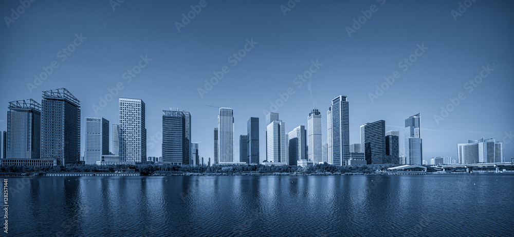 Obraz premium Serene Blue Skyline Over Tranquil Waters Capturing Urban Elegance
