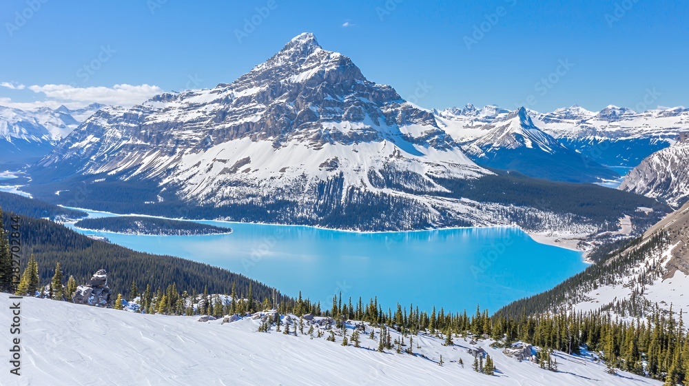 Stunning Panoramic View of a Snow Covered Mountain and a Vibrant Blue Lake Stunning Panoramic View of a Snow Covered Mountain and a Vibrant Blue Lake