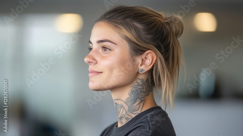 side profile of young tattoo artist working on detailed piece surrounded by clean minimalist studio decor
