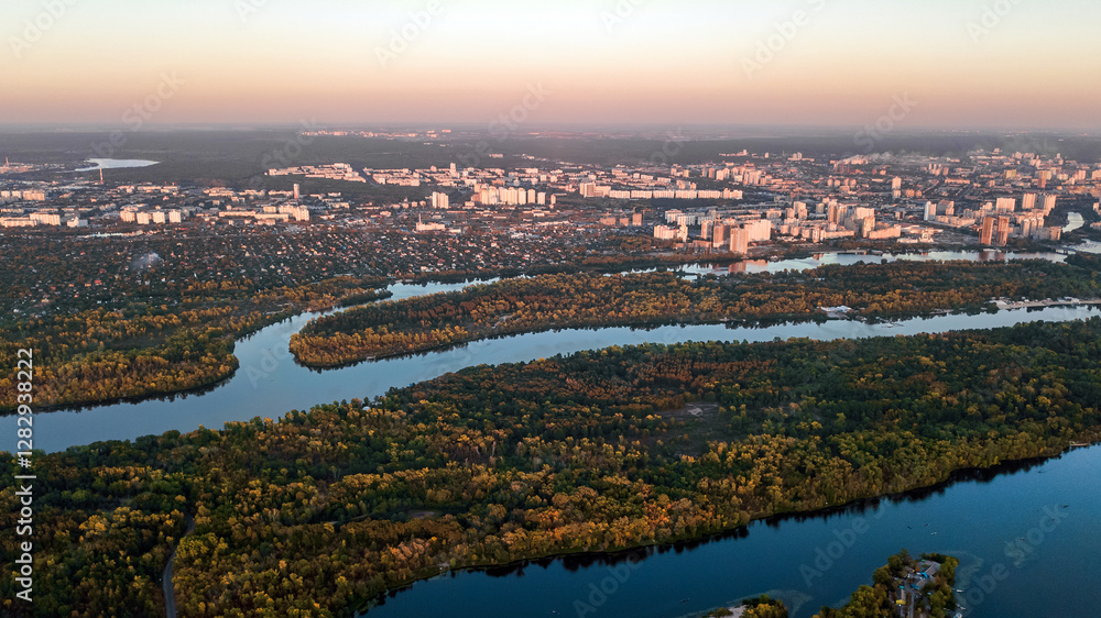 Fototapeta premium Kyiv city sunset skyline and Dnipro river aerial drone view from above, Kiev hills, pedestrian Park bridge and Dnieper river cityscape in autumn, Ukraine