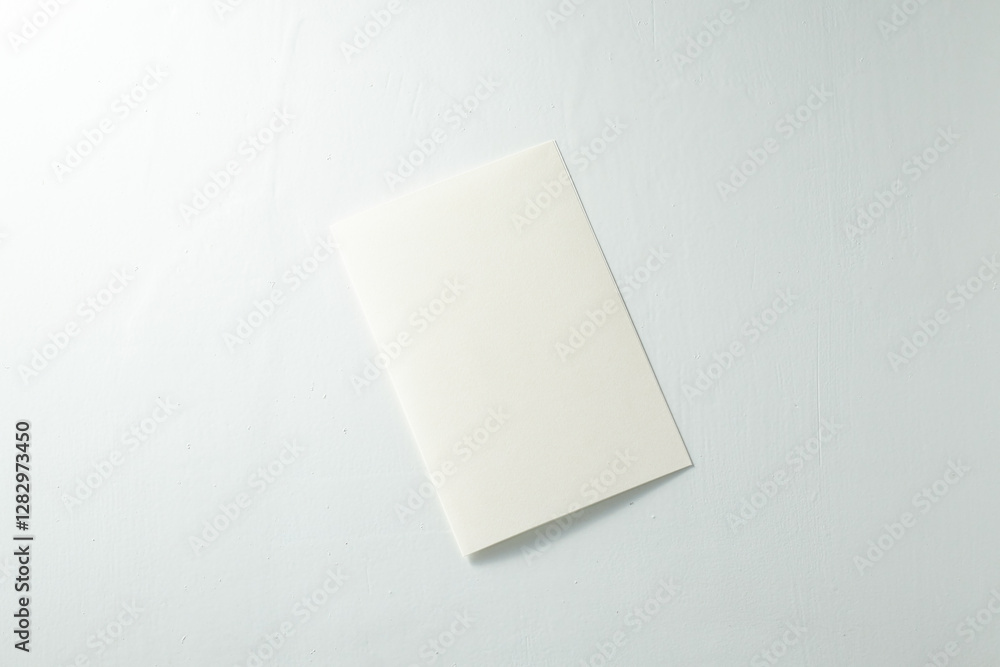 Plain White Notebook Resting on a Light Surface in a Minimalistic Setting Plain White Notebook Resting on a Light Surface in a Minimalistic Setting