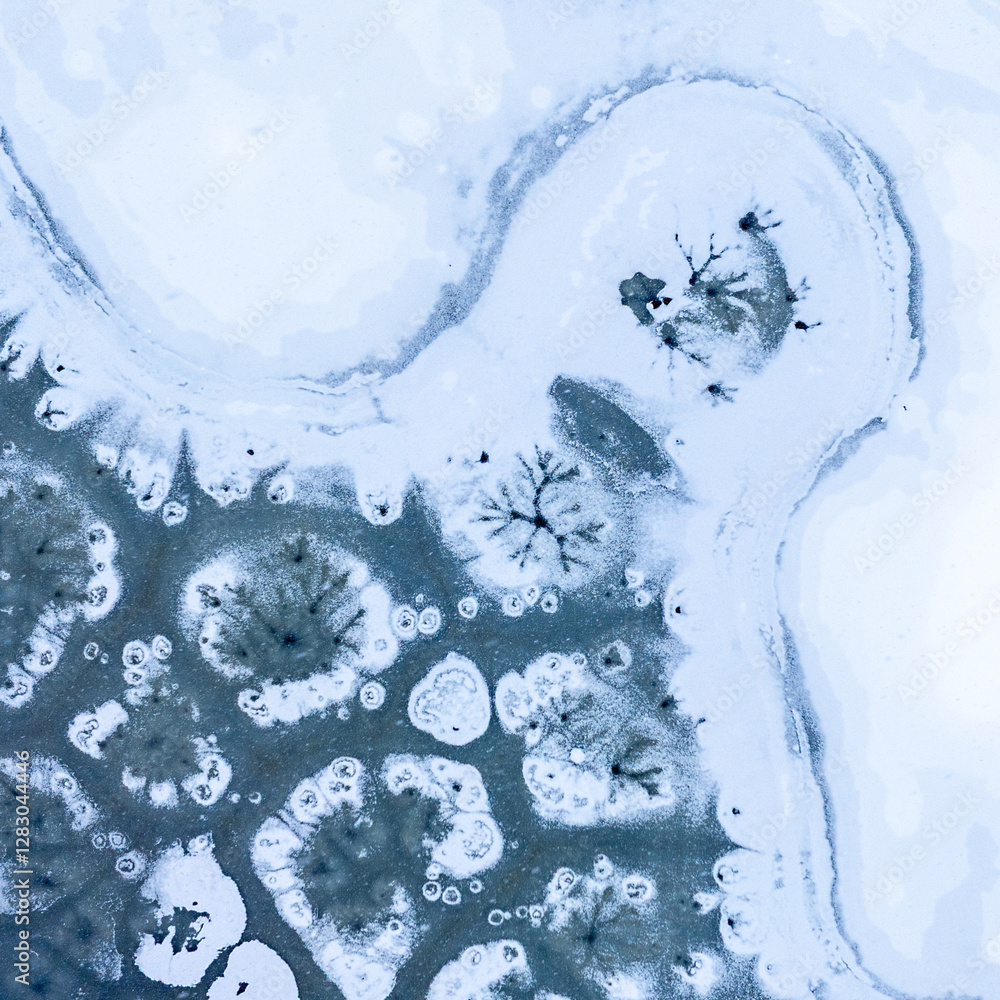 Winter abstract frozen textures. Aerial view of a frozen lake with intricate ice formations, showing unique patterns and natural beauty in a winter landscape.