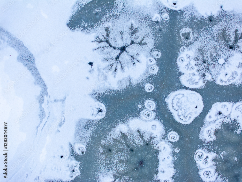Winter abstract frozen textures. Aerial view of a frozen lake with intricate ice formations, showing unique patterns and natural beauty in a winter landscape.