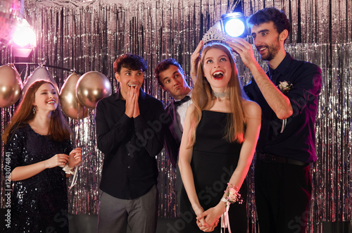 Young people crowning queen on prom night photo