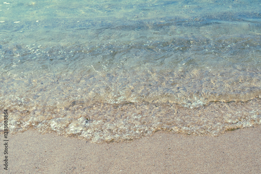 Gentle waves lap against a sandy beach under clear skies, perfect for tropical-themed designs. Gentle waves lap against a sandy beach under clear skies, perfect for tropical-themed designs.