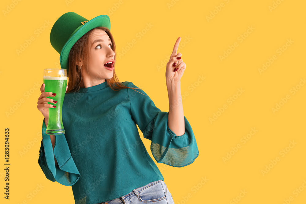 Surprised young woman with beer pointing at something on yellow background. St. Patrick's Day celebration Surprised young woman with beer pointing at something on yellow background. St. Patrick's Day celebration