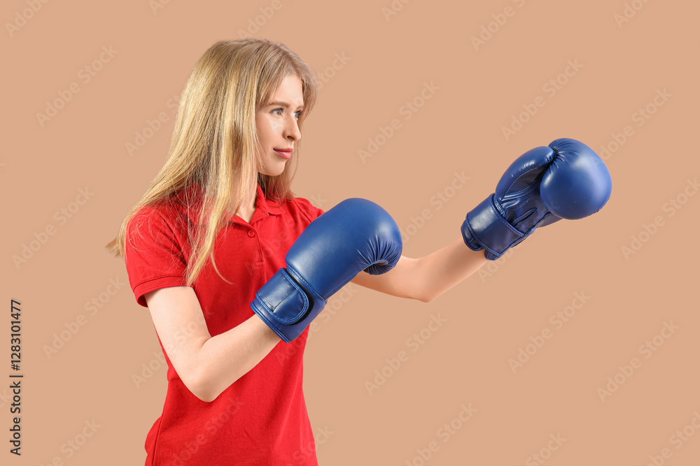 Beautiful young woman in boxing gloves on beige background. Women history month Beautiful young woman in boxing gloves on beige background. Women history month