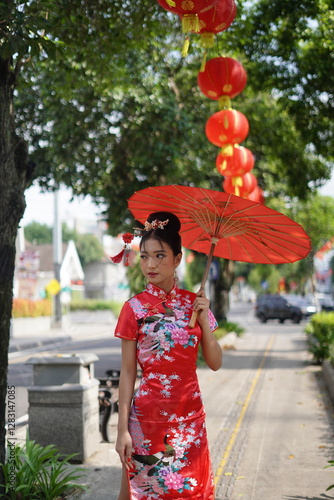 Woman in Red Cheongsam with Parasol on City Street