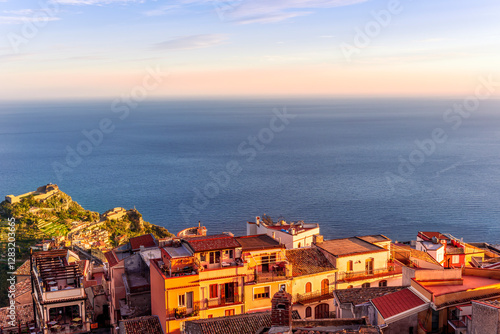 beautiful sunset scenic view of a coastline mountain town with nice roofs and streets with mountauns and hills and amazing cloudy sunset on background photo