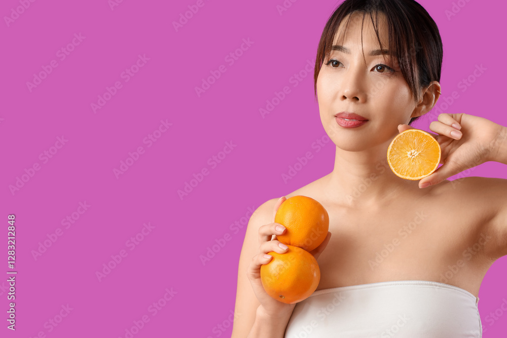 Young Asian woman with oranges on magenta background. Cosmetology concept Young Asian woman with oranges on magenta background. Cosmetology concept