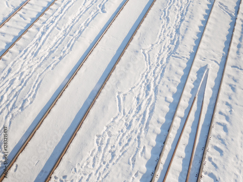 Railway tracks covered in snow during winter day