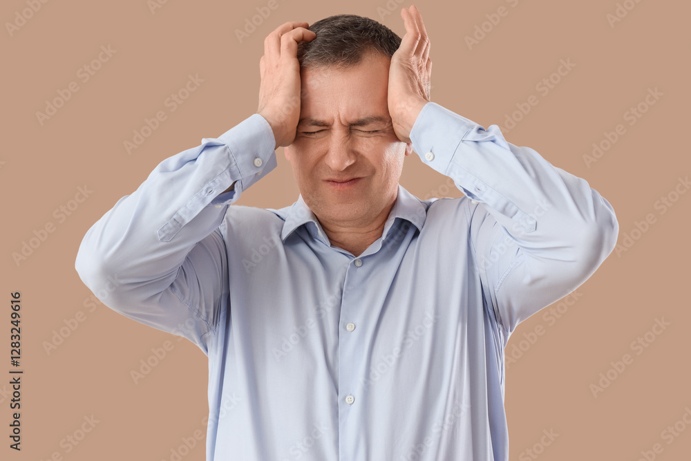 Mature businessman suffering from headache on beige background Mature businessman suffering from headache on beige background