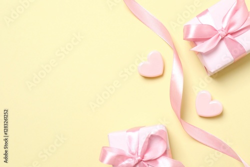 Beautiful gift boxes with hearts and silk ribbon on color background