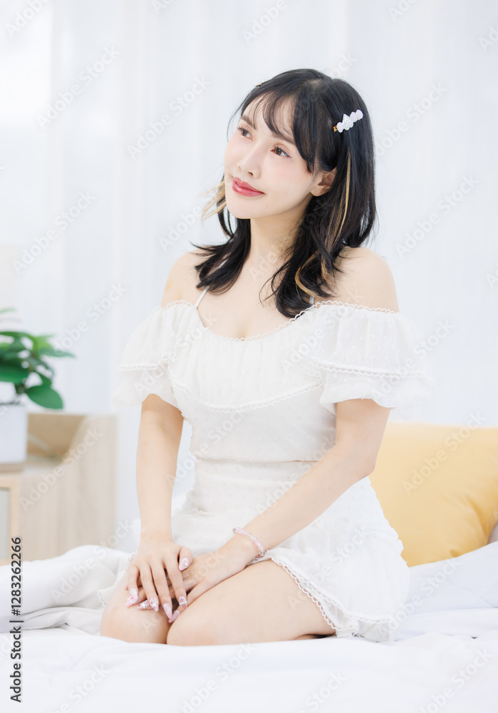 Asian happy young beautiful cheerful female sitting on cozy white bed smiling looking around in bedroom at home, Good morning calm comfortable healthcare relaxing resting well being peaceful concept. Asian happy young beautiful cheerful female sitting on cozy white bed smiling looking around in bedroom at home, Good morning calm comfortable healthcare relaxing resting well being peaceful concept.