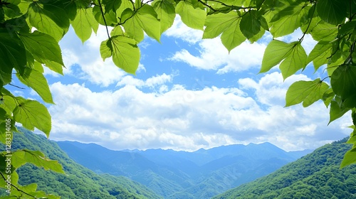 Green Leaves Frame Mountain Landscape Under Blue Sky