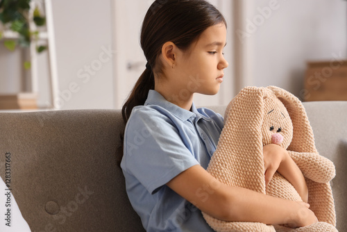 Sad girl with toy bunny sit...