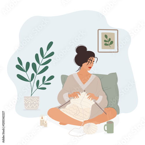 Flat vector illustration of a young woman sitting on the floor with a pillow behind her, knitting with needles and yarn. She is wearing a long sweater and is surrounded by candles, a cup of tea and