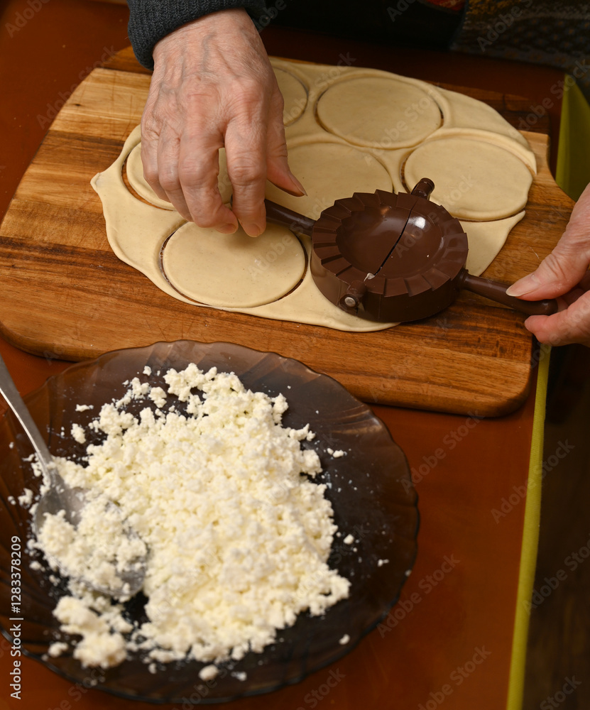 Woman skillfully fills dough circles with cheese in a warm kitchen