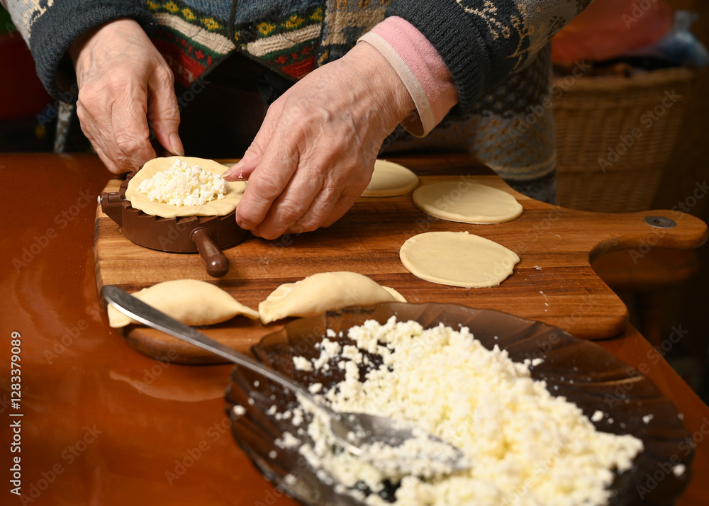 Woman skillfully fills dough circles with cheese in a warm kitchen.