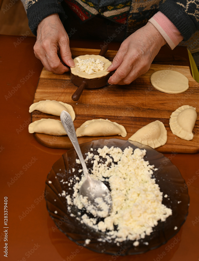 Woman skillfully fills dough circles with cheese in a warm kitchen