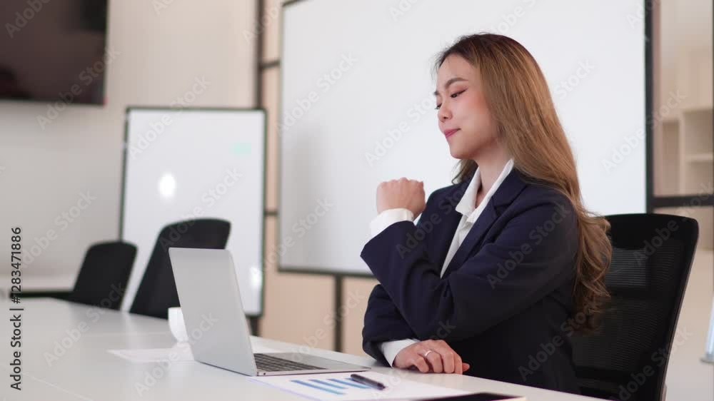 Young Asian businesswoman in a formal suit having a video conference on a laptop in a modern office Young Asian businesswoman in a formal suit having a video conference on a laptop in a modern office