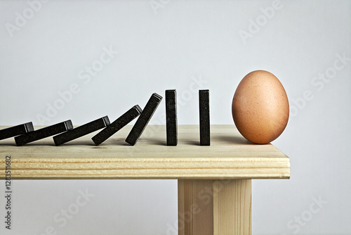 Tessere del domino con uovo in bilico sul piano del tavolo
